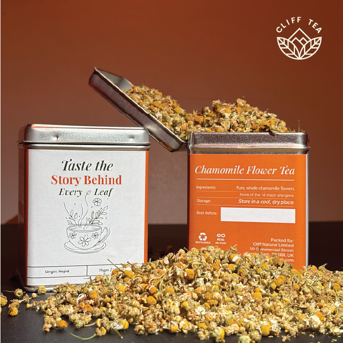 Chamomile flowers and tea cup on wooden surface