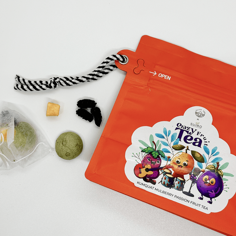 Crazy Fruit Tea pouch with sachets, dried kumquat and mulberry beside it